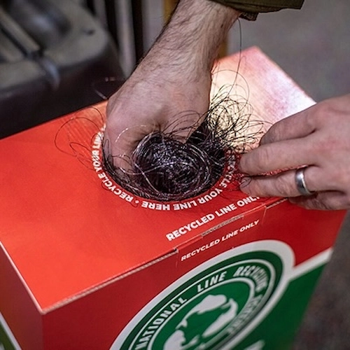 Hand with fishing line putting into line recycling bin