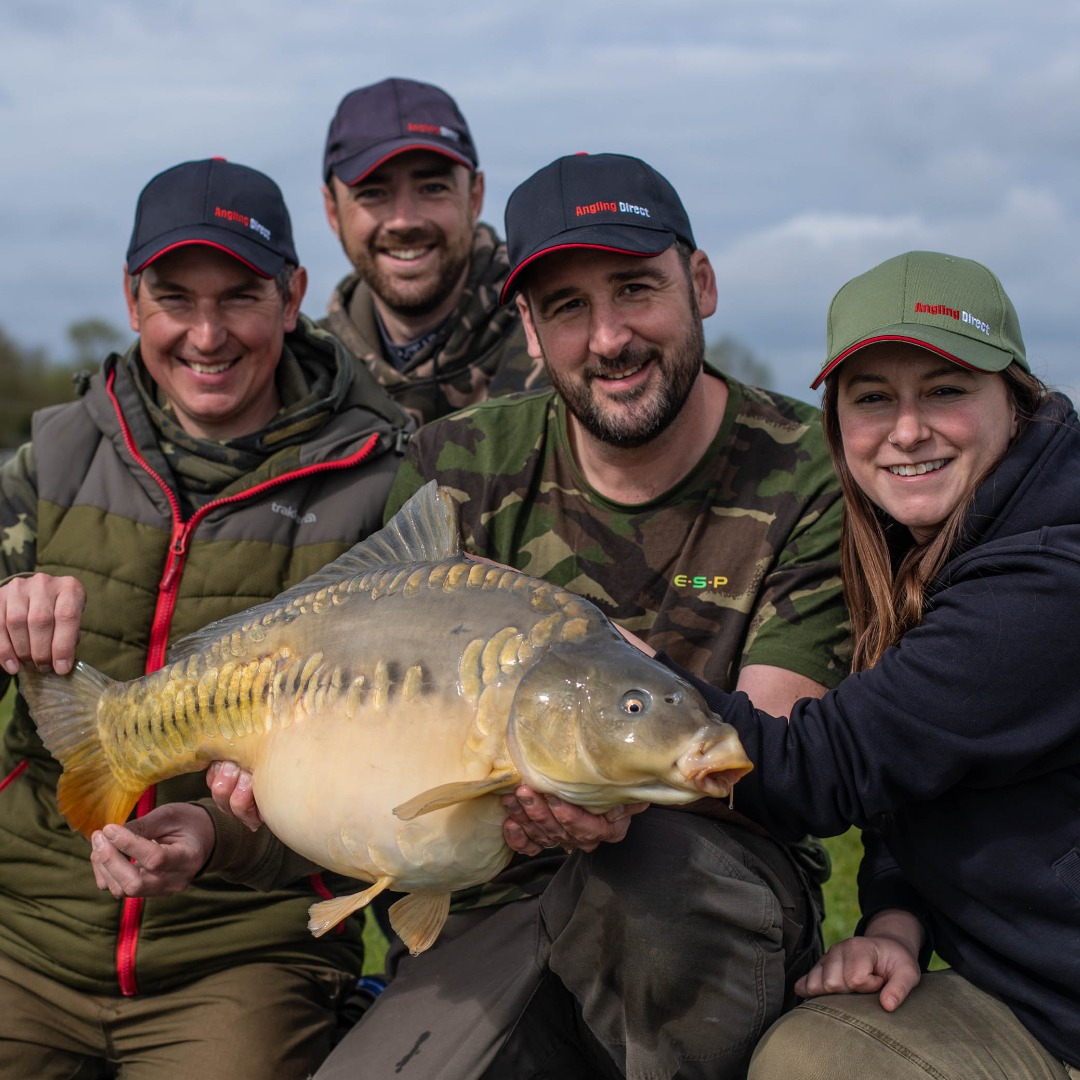 Group of four anglers holding carp, Team AD.