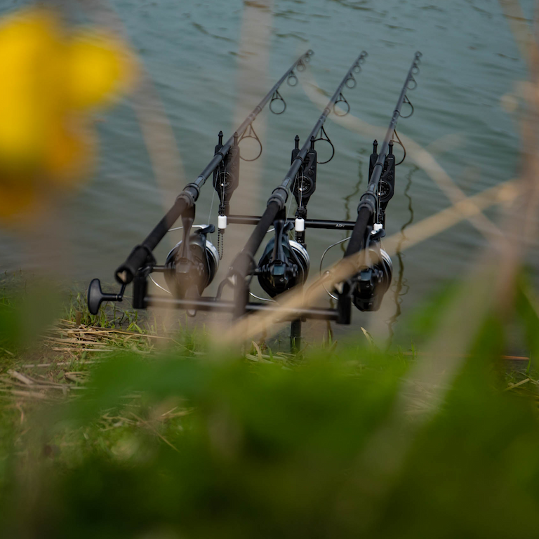 Three fishing rods setup at lakeside